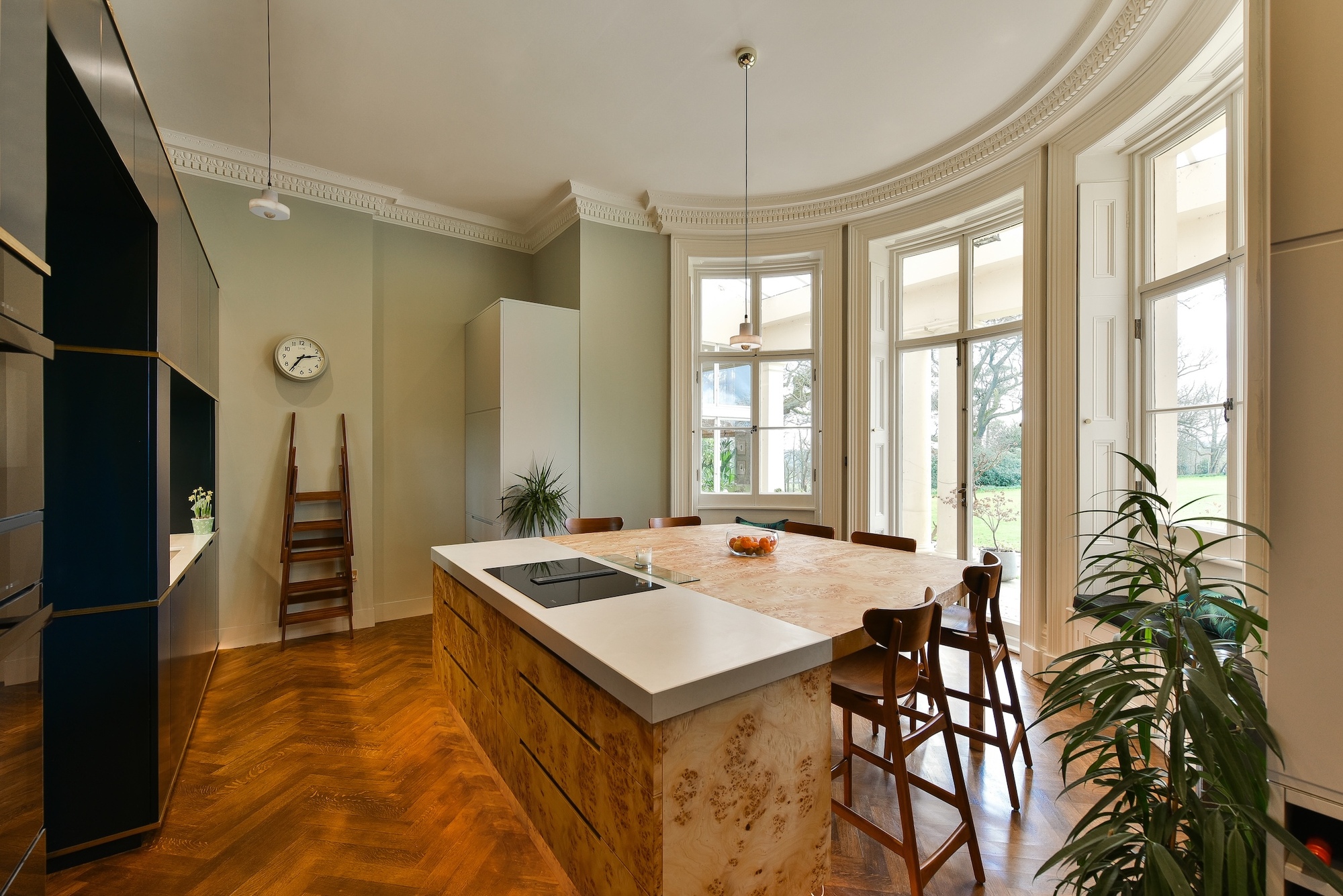 A kitchen with a burl wood island with an area for seating