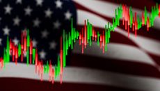 A vibrant, wide-angle view of a stock market bar graph with prominent green and red candlestick indicators layered over a blurred, cinematic background of the American flag.
