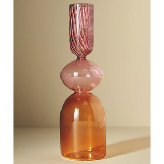 orange and pink glass candlestick in a curved pillar design