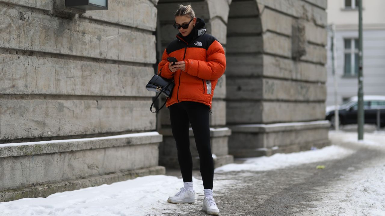 BERLIN, GERMANY - FEBRUARY 15: Alessa Winter wearing The North Face orange jacket, white Nike Air Force sneaker, Balenciaga black bag and black Ellesse leggings on February 15, 2021 in Berlin, Germany. (Photo by Jeremy Moeller/Getty Images)