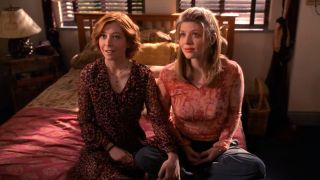 Willow and Tara holding hands while sitting on a Bed on Buffy the Vampire Slayer.