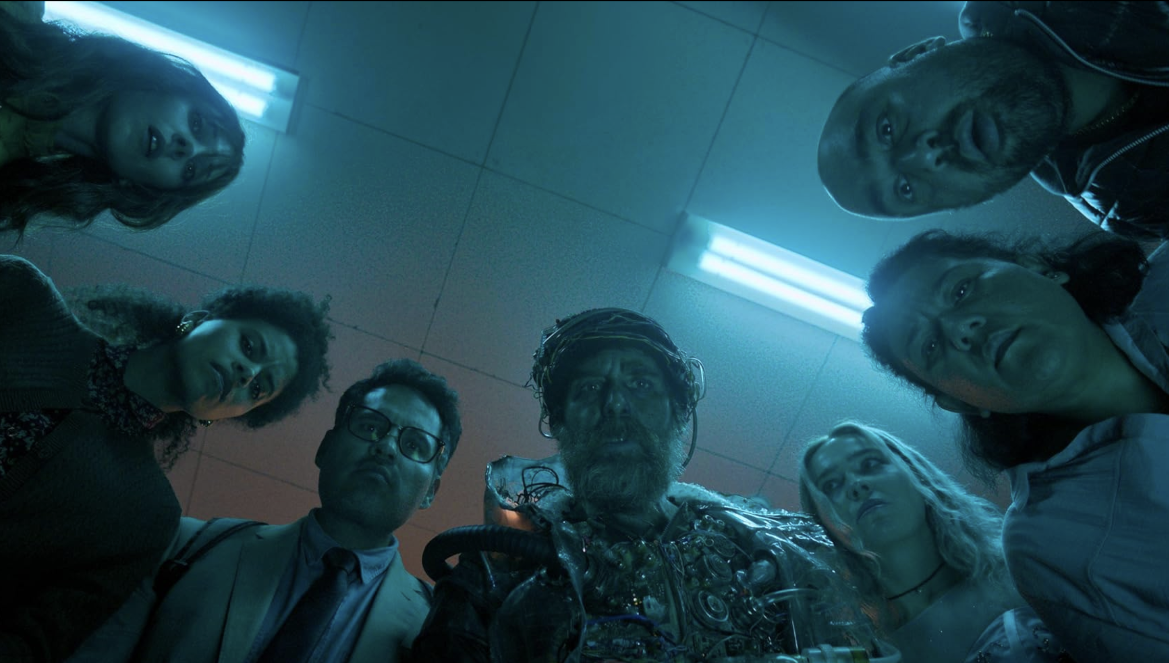 an image from the film showing the protagonists looking down into the camera in a circle