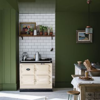 green kitchen area with cookpot and wooden table