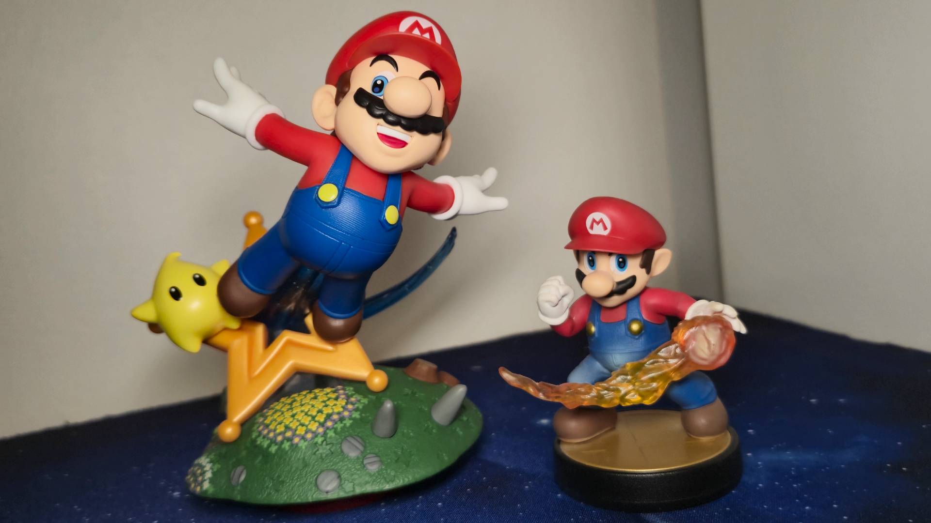 Photo of the Mario Super Mario Galaxy amiibo next to the Smash Bros Mario amiibo for scale.