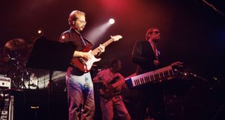 Steely Dan's Walter Becker plays his Strat onstage at Madison Square Garden, flanked by Donald Fagen