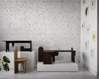 Gallery interior showing asymmetric wooden tables on a plinth