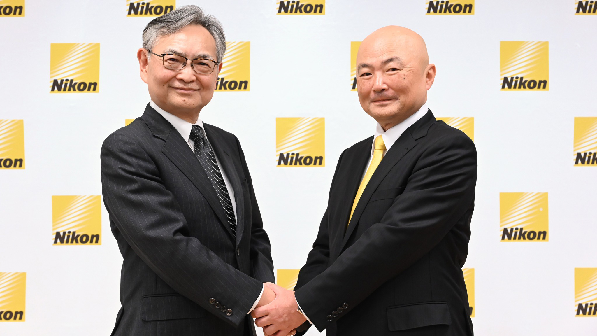 The new Nikon CEO Yasuhiro Ohmura (on the right) shaking hands with Muneaki Tokunari as Representative Director and Chairman