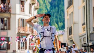 Tom Evans salutes the crowd at the UTMB finish line in Chamonix 2022