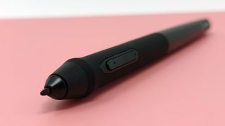 XP-Pen Deco 01 V2 stylus lying on top of a pink drawing tablet