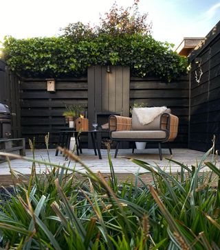 Outdoor fireplace with chair, decking and greenery