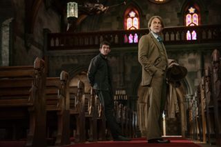 josh oconnor and daniel craig as benoit blanc walking through an ornate church in the first look photo from knives out wake up dead man