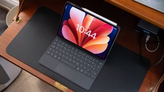 Overhead view of the Xiaomi Pad 8 Pro in keyboard case on a desk, with the display tilted back and stylus magnetically attached.