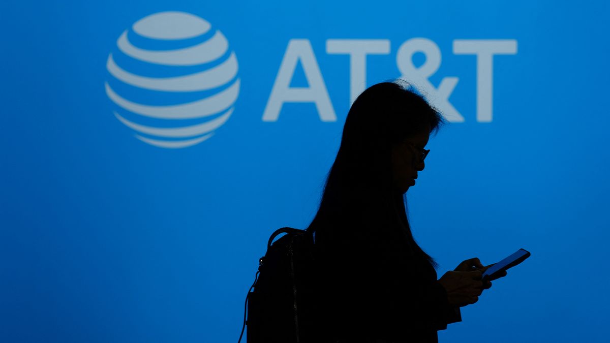 AT&amp;T logo and branding on a blue background pictured with silhouetted woman in foreground.