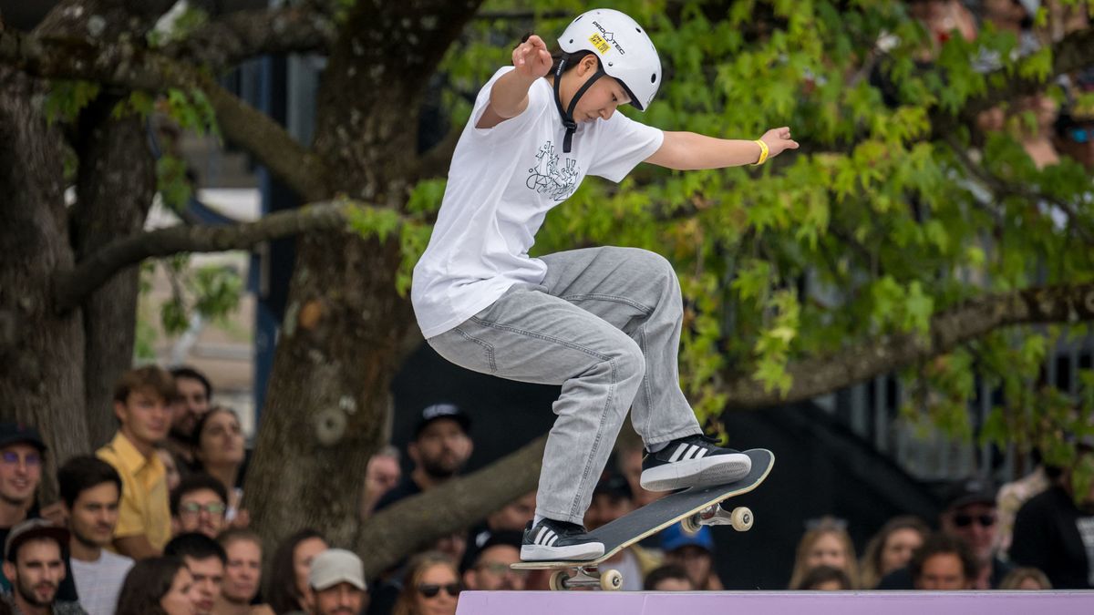 Momiji Nishiya of Japan pull a manual on top of a ramp, wearing grey jeans with a white t-shirt and helmet, in the Street Skating ahead of the 2024 Olympic Games.