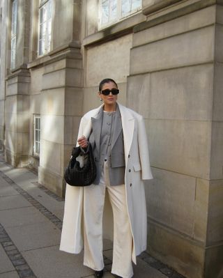 woman wearing a white coat and jeans and grey blazer in Copenhagen