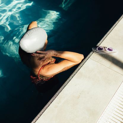 woman wearing swimming cap standing in pool