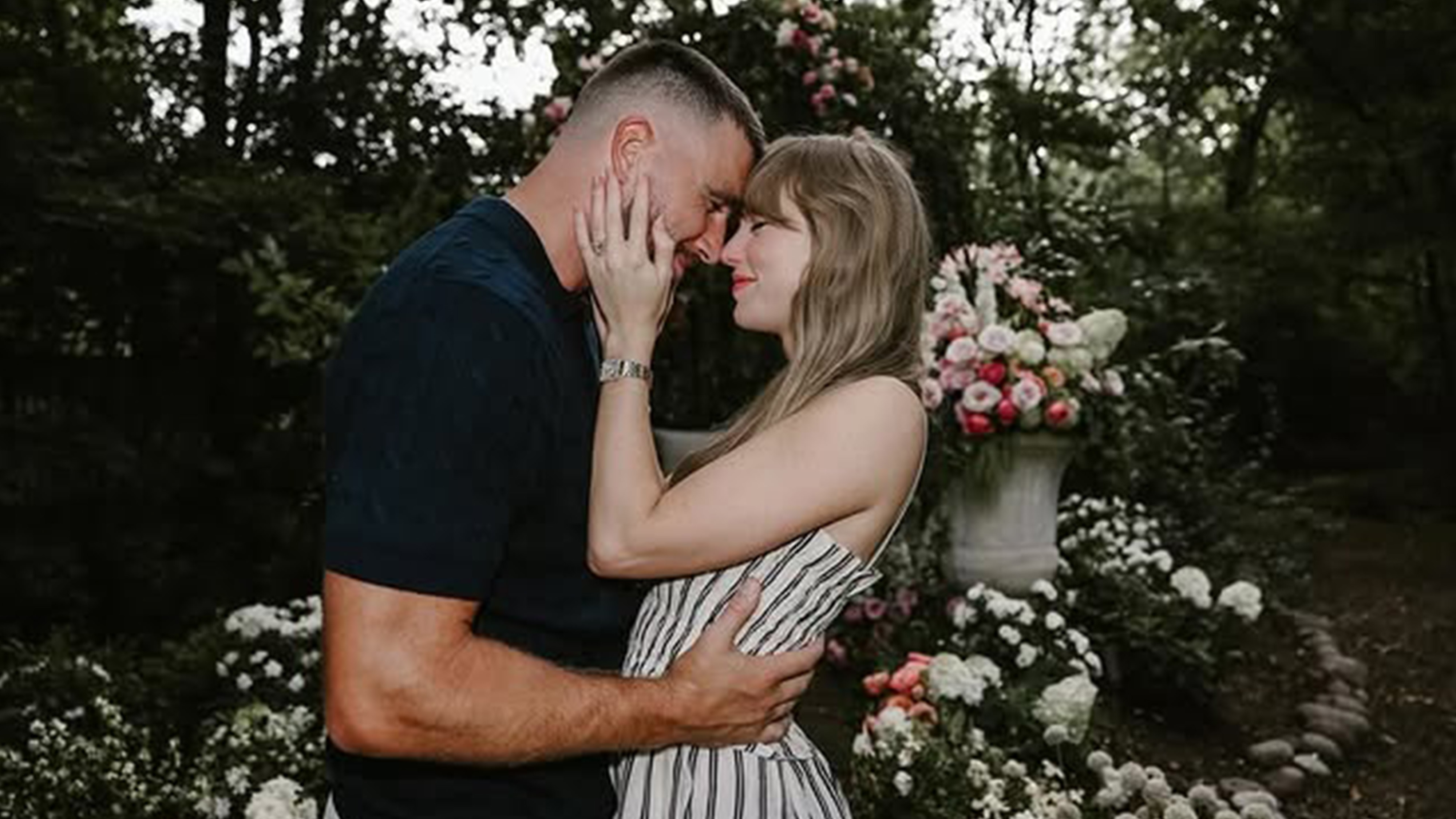 Taylor swift wears a stripe dress, travis kelce wears a black top.