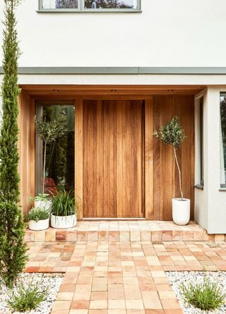 Wooden front door with olive trees