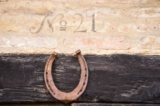 Closeup of house number 21 on the old half-timbered building with horseshoe under the number. It was common to put the horseshoe above the door frame