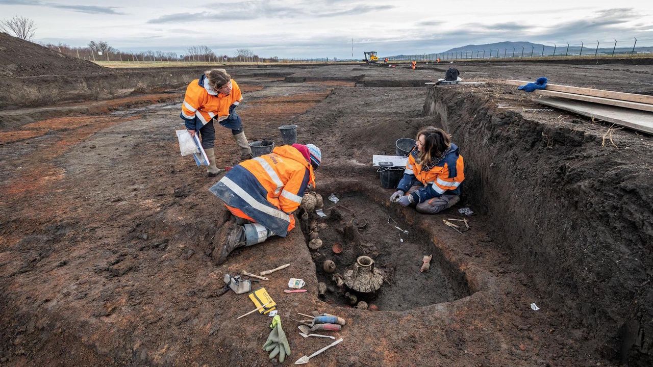 Archaeologists examine the 2,000-year-old burial of the child and puppy,