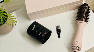 The L'ange Le Volume dryer brush on a white table next to its small cleaning brush and protective cover for L'ange blow dryer brush review.