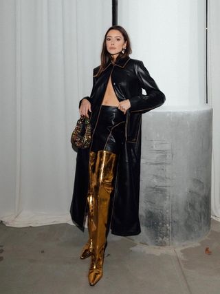 woman wearing leather mini skirt with gold over-the-knee boots with leather coat