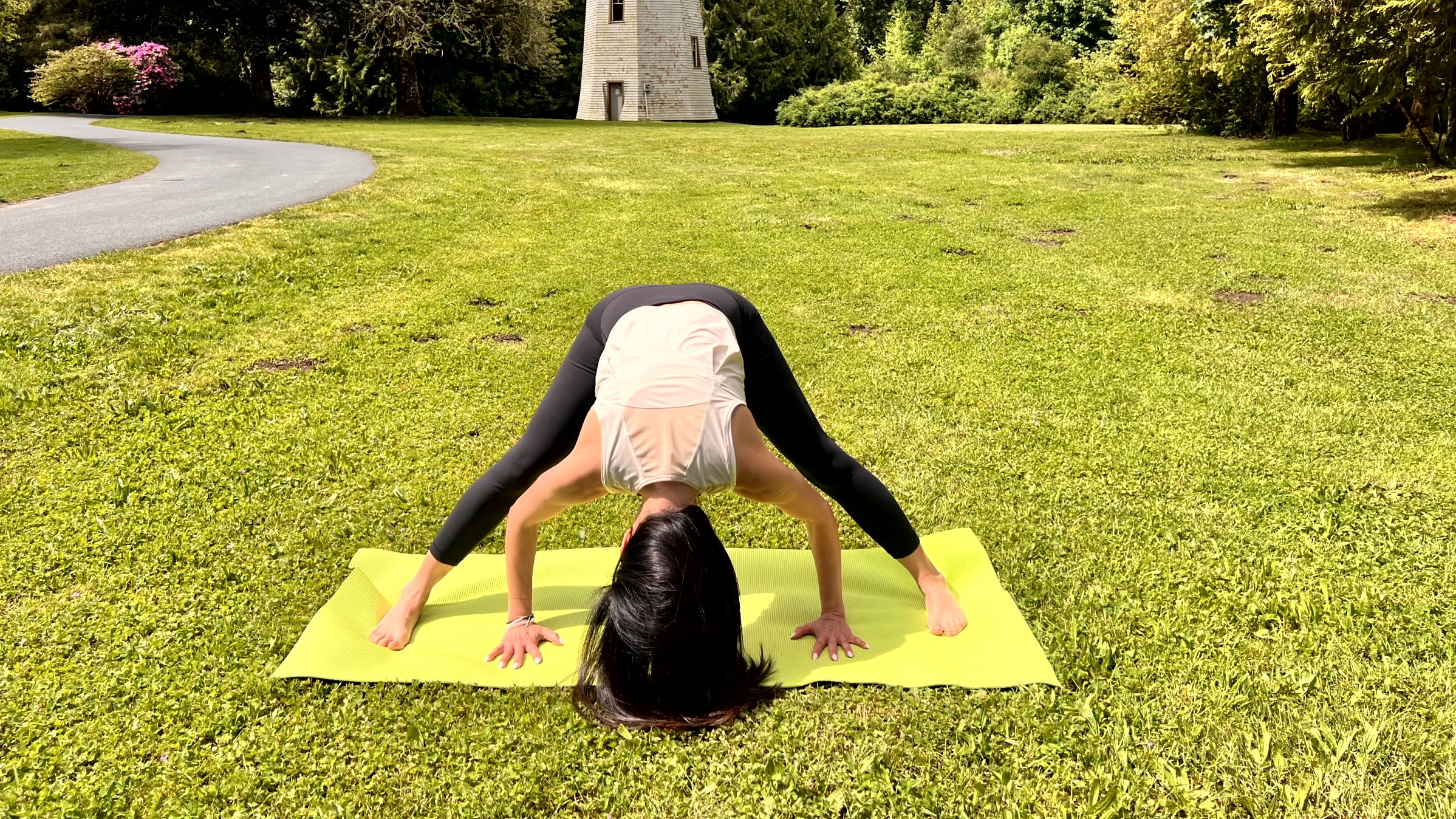 Woman in yoga pose on a mat in her garden