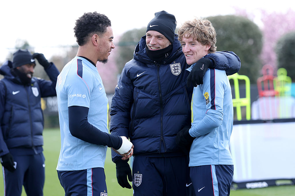 Thomas Tuchel, Head Coach of England, talks to Morgan Rogers and Anthony Gordon of England during a training session at Tottenham Hotspur Training Centre on March 28, 2026 in Enfield, England.