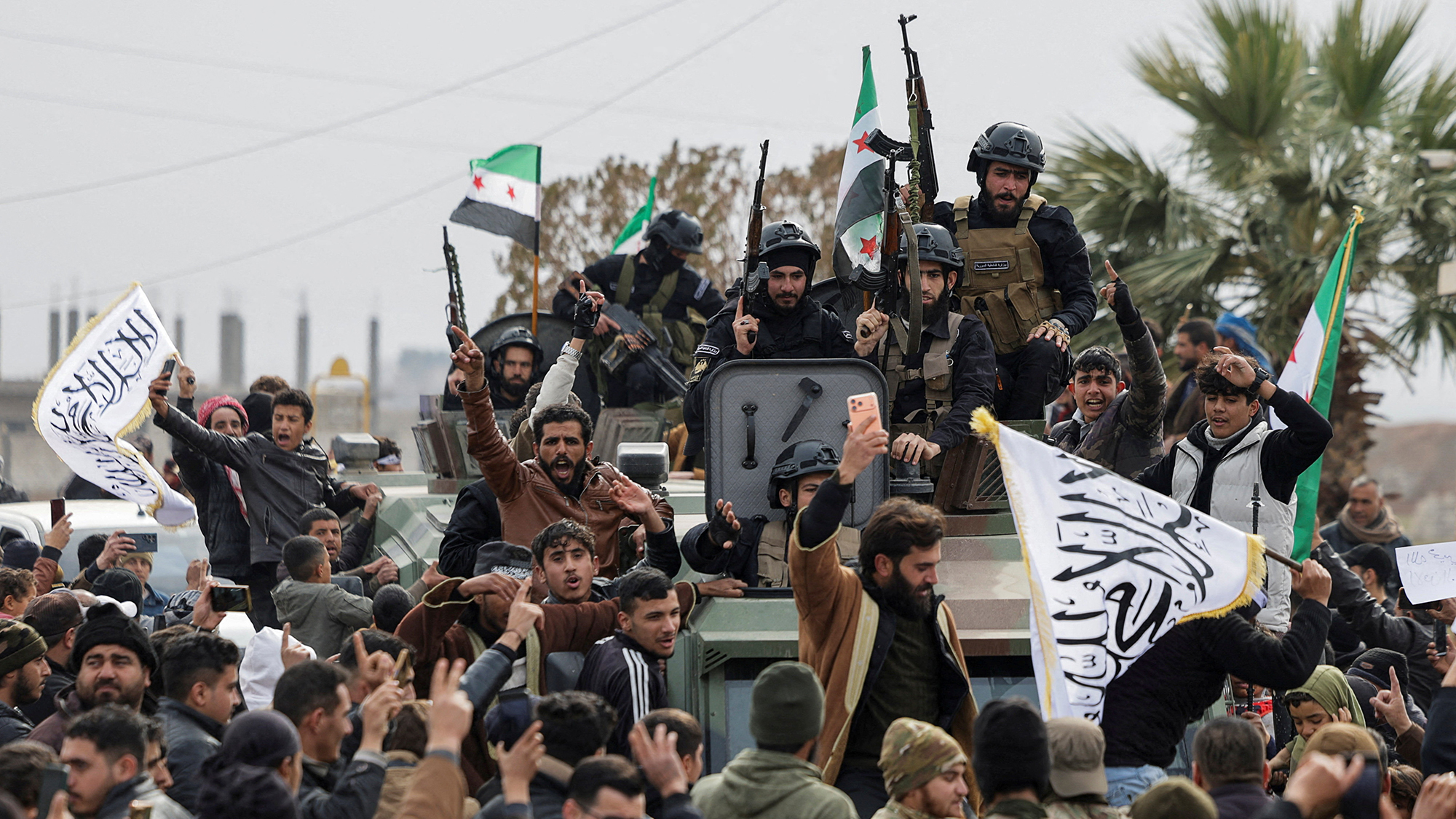 People celebrate as government security forces enter the city of Qamishli in Syria, following an agreement between Damascus and the Syrian Democratic Forces