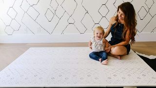 Image of a mum and baby sat on a mat