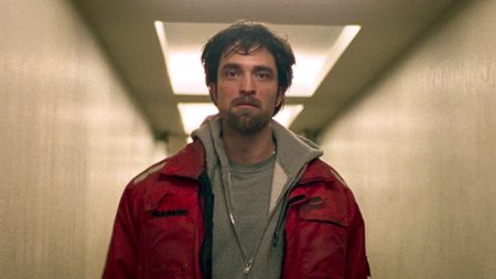 Connie Nikas (Robert Pattinson) walks down a corridor in in Good Time