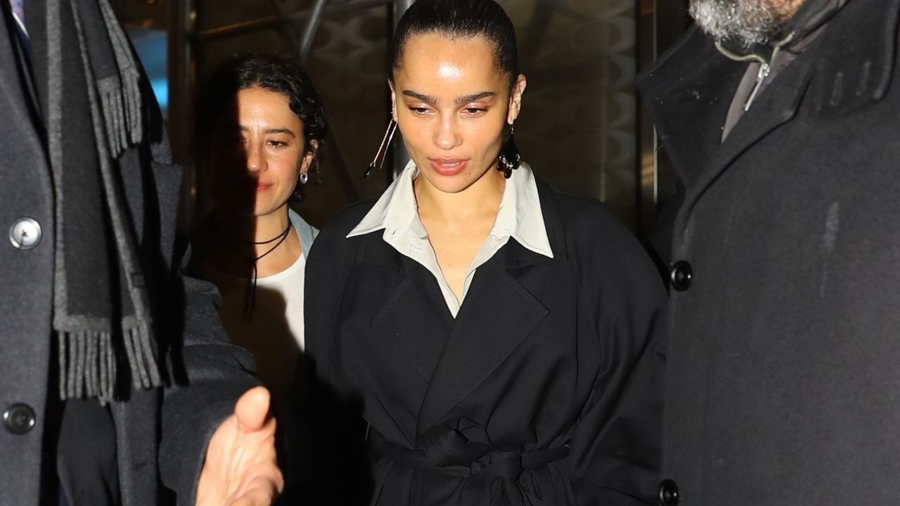 Zoë Kravitz in New York City wearing a black wrap coat and a shirt peeking out from underneath