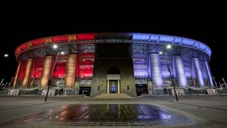 Puskas Arena lit up half red and half blue at night for the Europa League Final
