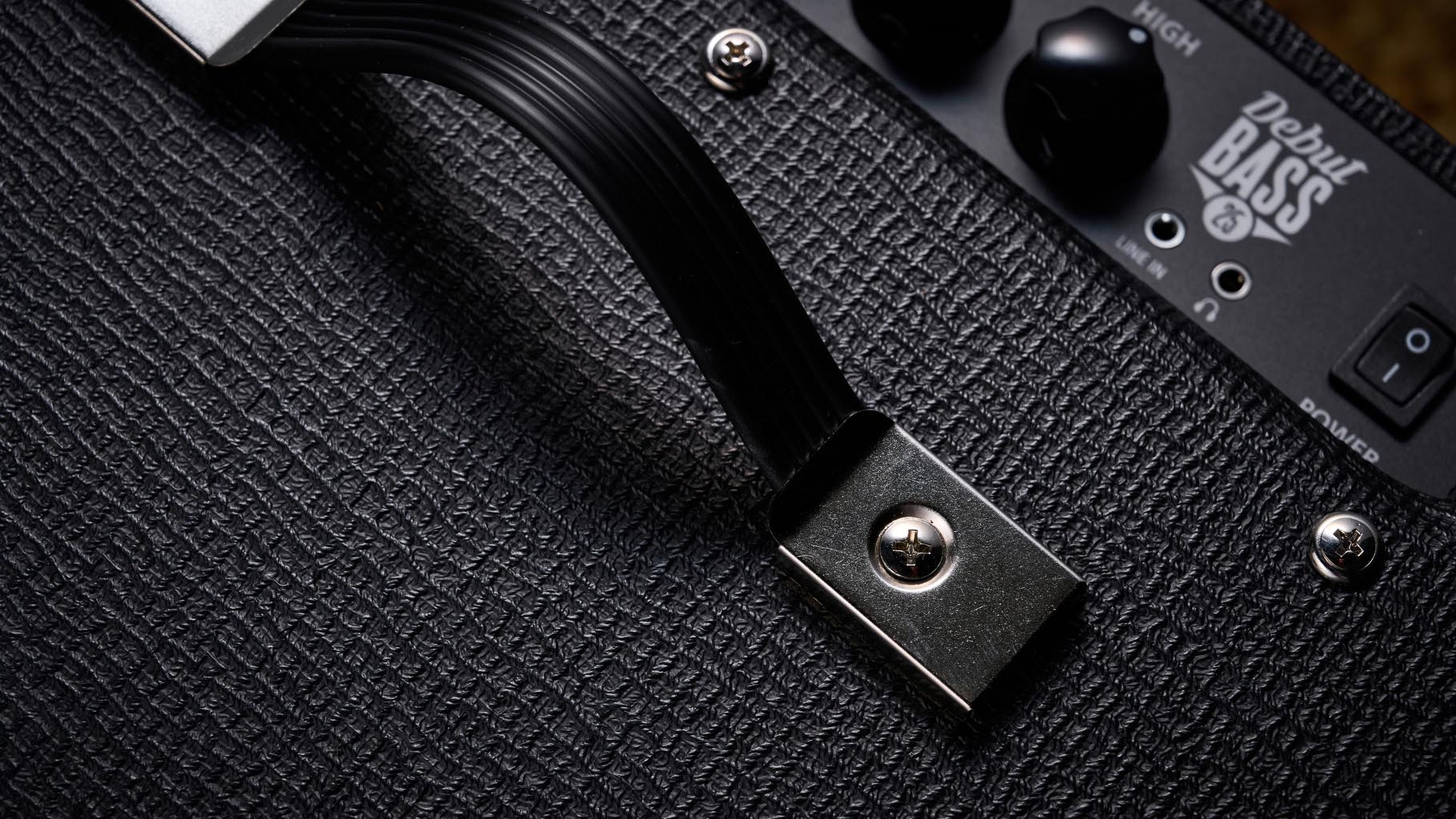 Blackstar Debut Bass 25: this compact little combo is finished in black with matching grille clothe and is photographed in close-up against a stone floor and weaved rug.