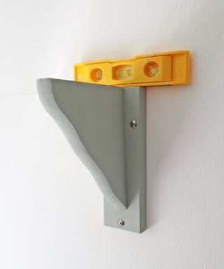 checking the level of a shelf bracket