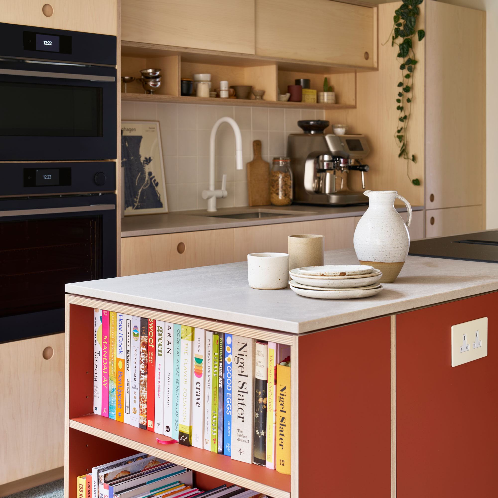 Wooden kitchen cabinets with a red kitchen island and cook books