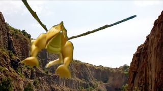 A shot of a bad CGI dragon flying up into the sky through some cliffs