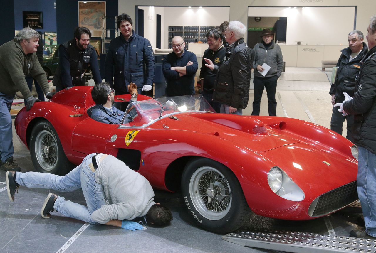 People install a 1957 Ferrari 335S Spider Scaglietti car valued at more than 32 millions of euros on February 2, 2016 at the Retromobile show in Paris, as part of a sports car auction schedul