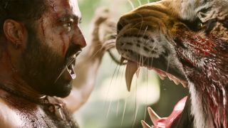 A man screaming while face to face with a roaring tiger