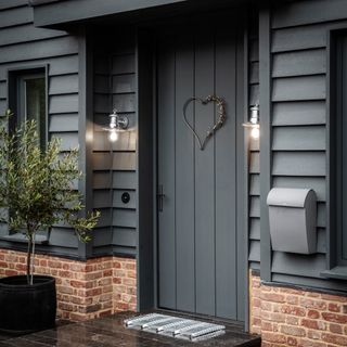 grey front door with door mat and lights