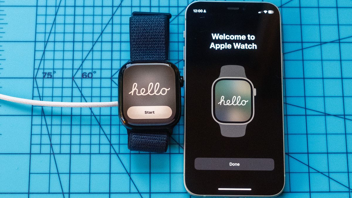 Close up of an Apple Watch 10 screen showing &quot;Hello&quot; next to an iPhone with the same message. Both are sitting on a light blue mat