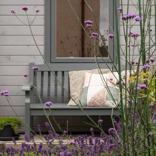 garden with bench seating and verbena and lavender in foreground