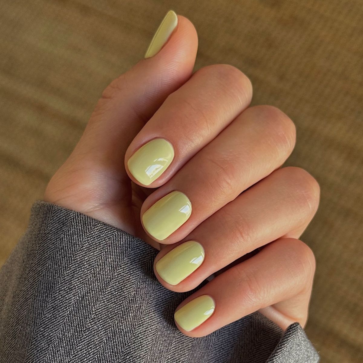 A close-up picture of a short, pistachio green manicure
