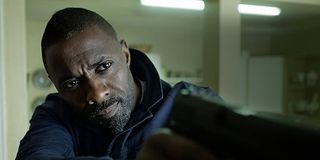 Idris Elba holding a gun in The Take