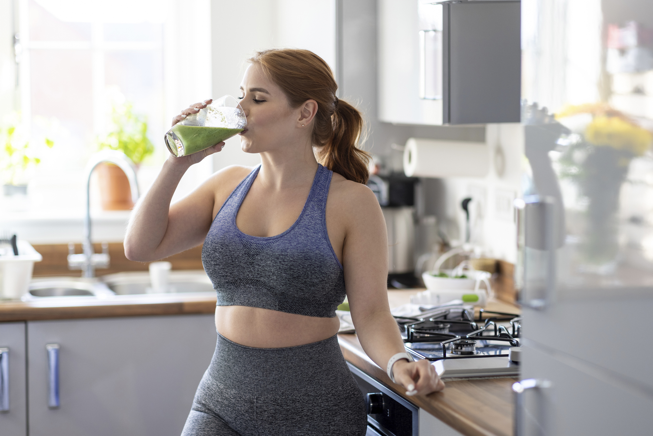 Wedding diet: a woman drinking a smoothie in workout gear
