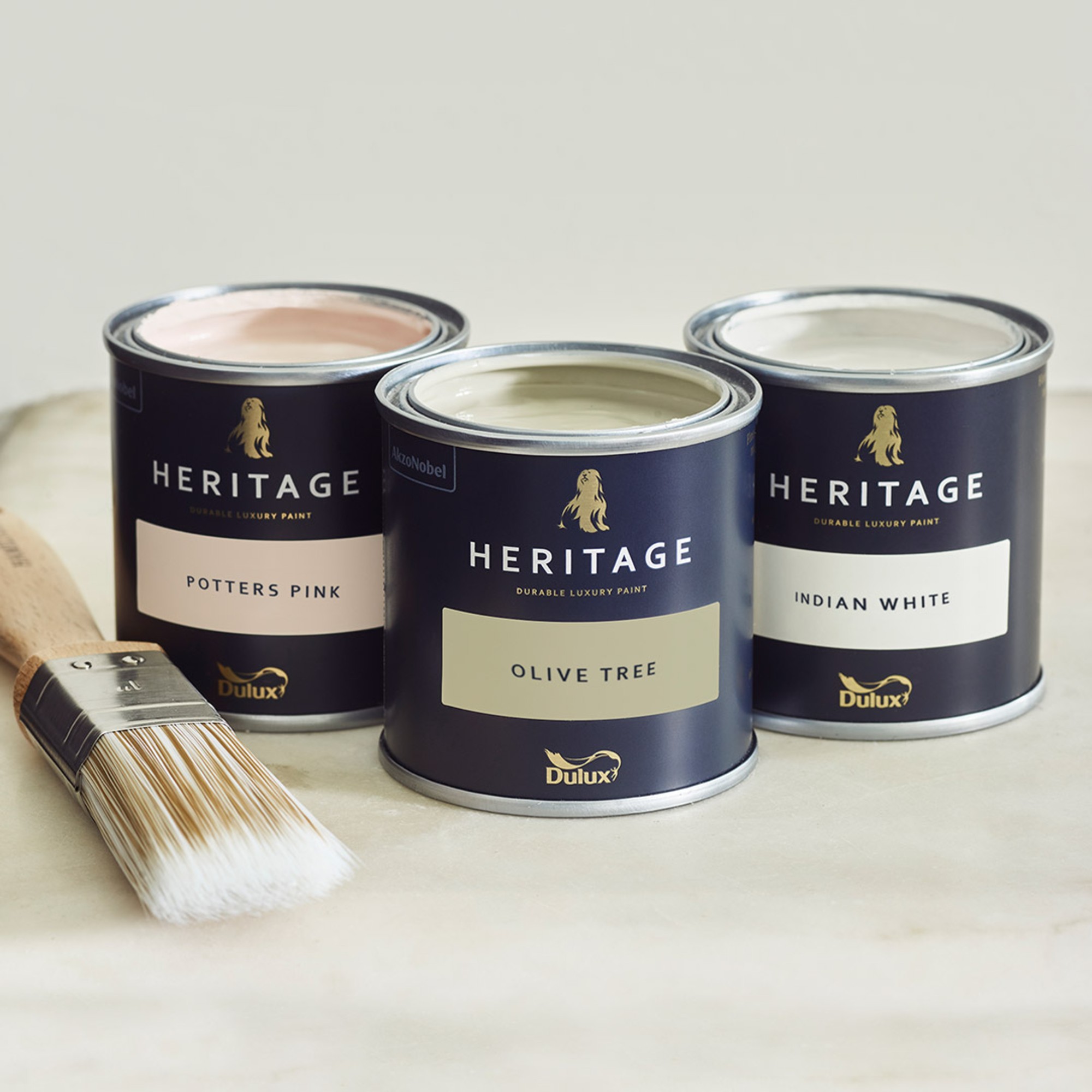 Dulux Heritage paint tins in shades Potters Pink, Olive Tree and Indian White
