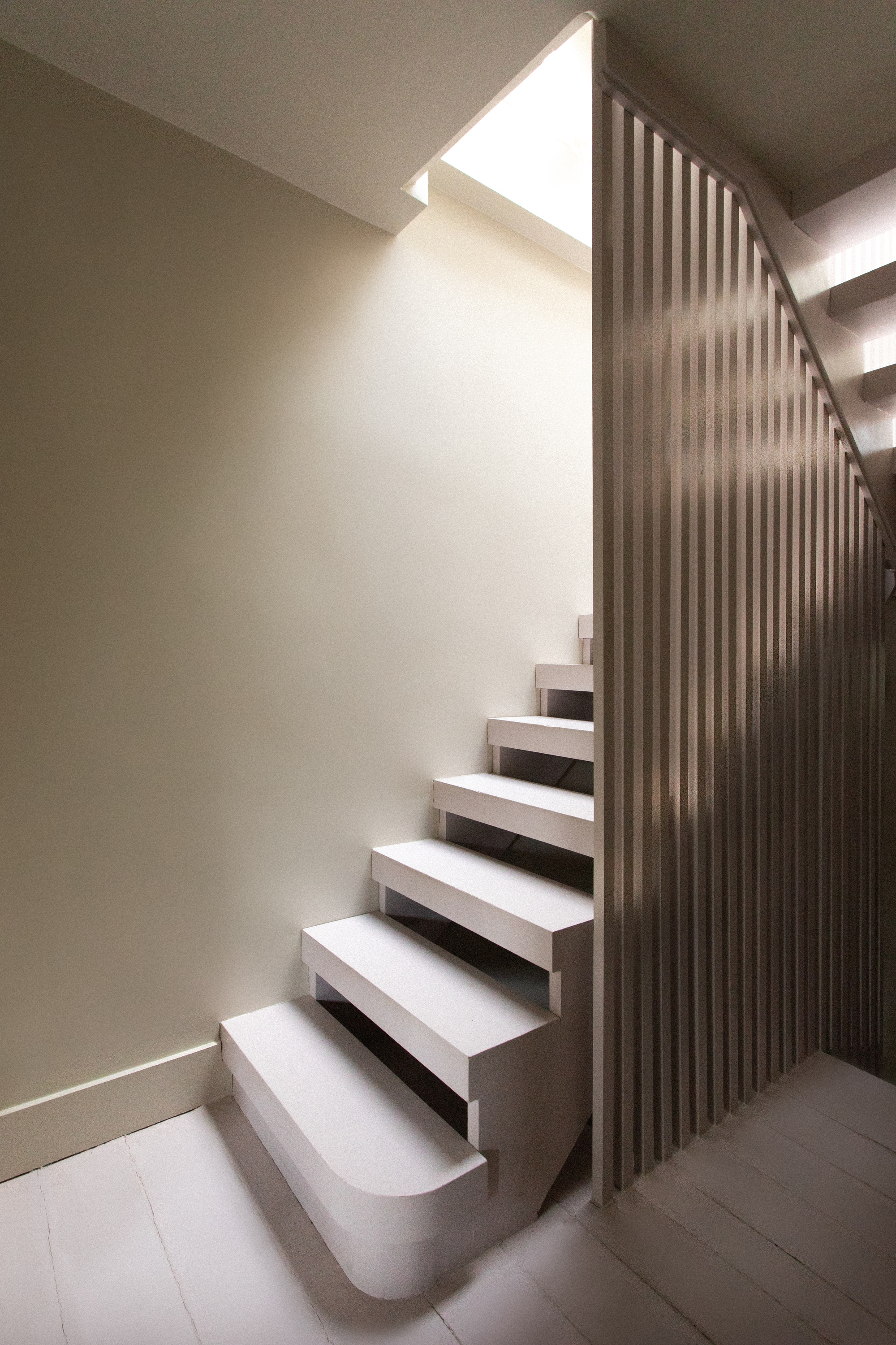 A set of stairs leading into a loft with a modern wooden slatted partition wall