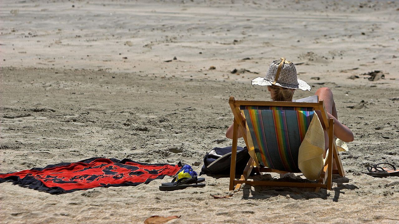 Woman reading a book in a deckchair 