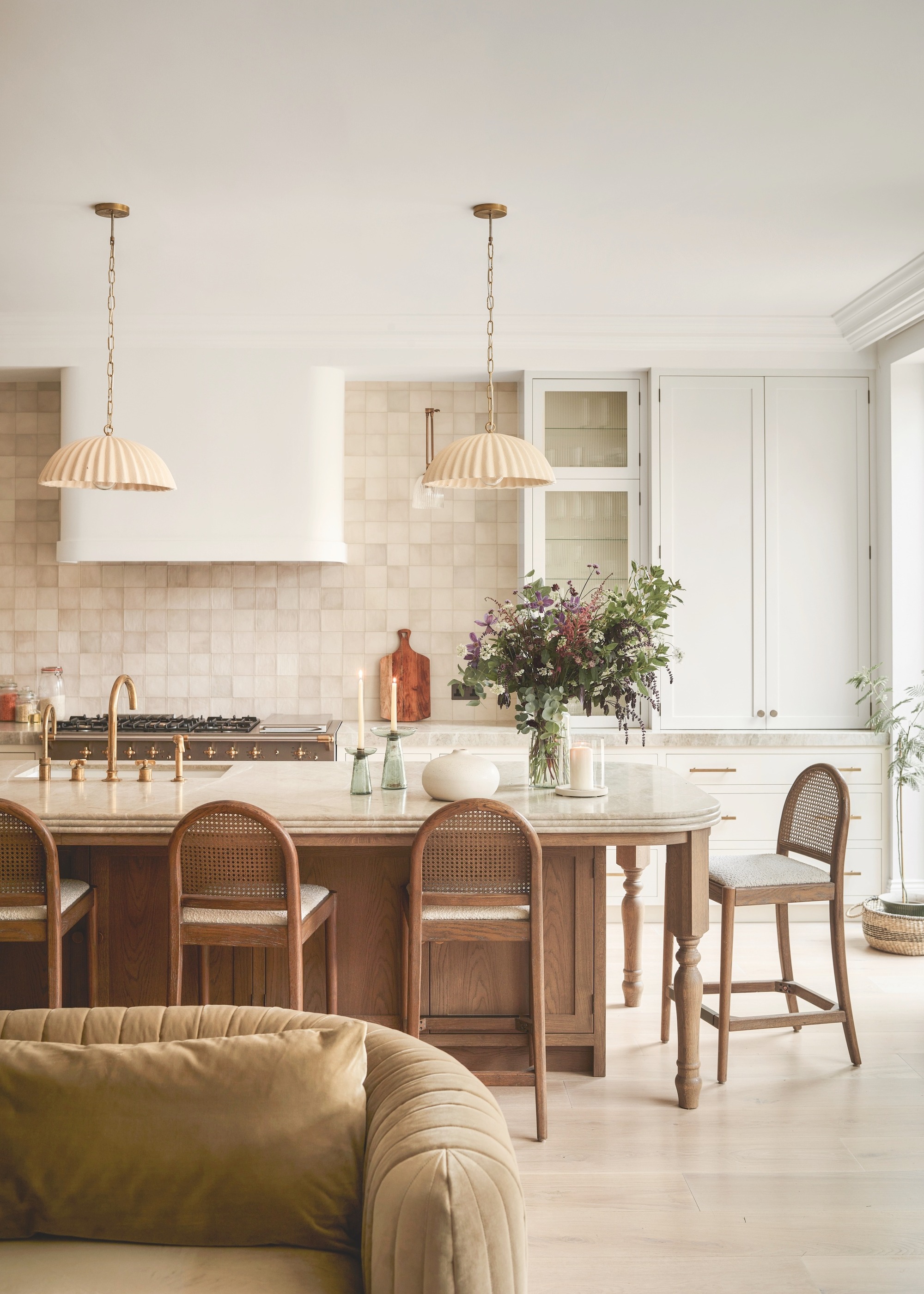Large kitchen island with timber cabinetry and marble countertop in white kitchen with tiled wall