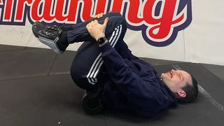 Man doing lower back foam roller exercise
